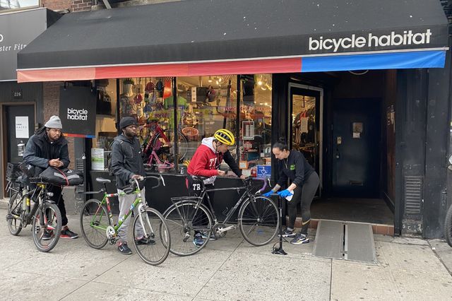 Customers stand outside a bustling Bicycle Habitat in Chelsea